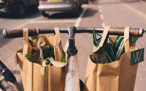 Sac en papier accrochés au guidon d'un vélo après les cours